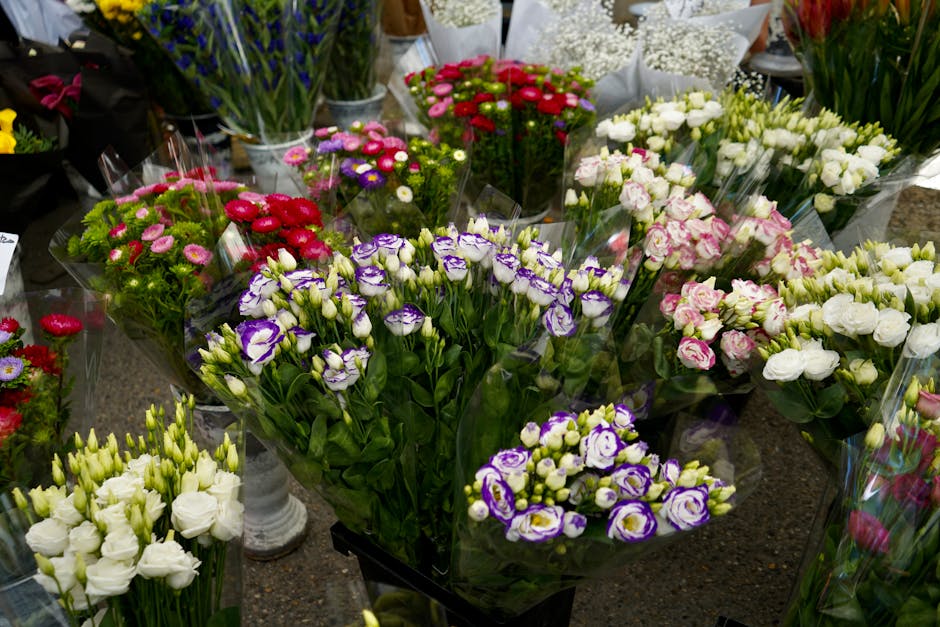An assortment of fresh floral bouquets arranged on a display table at Musewell Hill Florist's shop, featuring various flowers including purple and white eustoma, pink and white roses, red and pink dai